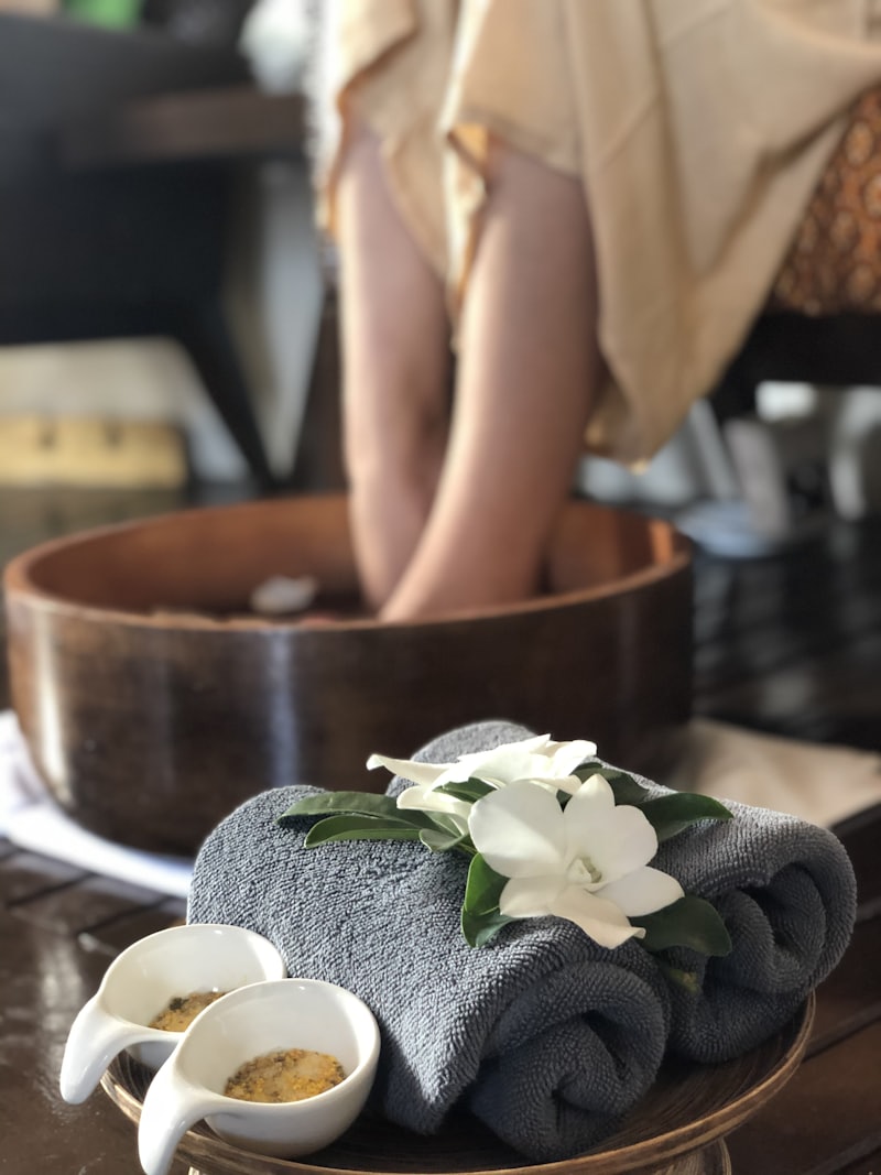 Kosmetische Fußpflege mit Blüten und Handtüchern